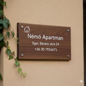 a wooden sign on the side of a building at Némó Apartman in Eger