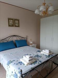 a bedroom with a bed with blue sheets and blue pillows at Casa Bea in Castiglione