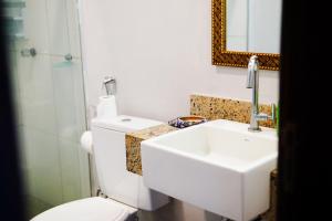 a bathroom with a toilet and a sink and a mirror at Barra Quintal Apartamento 04 in Barra Grande