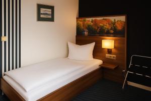 a small bedroom with a white bed and a lamp at Bettenburg Hotel Hamburg in Hamburg +38 photos