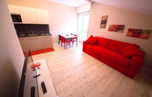 Una sala de estar con un sofá rojo y una mesa. en Appartamenti Aosta, en Aosta 4 fotos más
