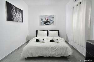 a white bedroom with a bed with two pillows at אגם בגליל - וילה ו-3 סוויטות עם בריכה מחוממת בעבדון in Wadi Keren