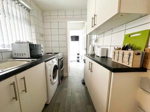 een keuken met een spoelbak en een wasmachine bij Hill View in Charlton