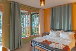 Un dormitorio con una cama y algunas ventanas en Mua Hills Tented Camp, en Katelembu