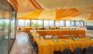 Habitación grande con mesas, sillas y mantel amarillo. en Mua Hills Tented Camp, en Katelembu