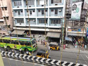 a green bus and cars on a city street at Swamy Residency in Vellore
