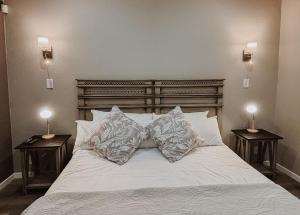 a white bed with two nightstands and two lamps at Santai guesthouse in Brits +87 photos