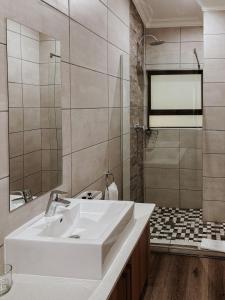 a bathroom with a white sink and a shower at Santai guesthouse in Brits