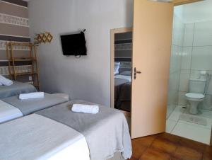 a room with two beds and a bathroom with a toilet at POUSADA AREIAS DE PAJUÇARA in Maceió +33 photos