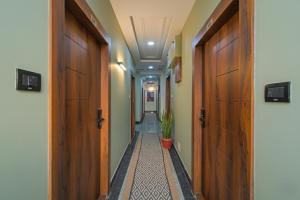 a hallway with two wooden doors and a plant at Hotel Broholi Height Inn Near Hafeezpet Railway Station in Hyderabad