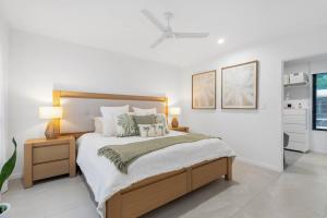 een slaapkamer met een groot bed met 2 lampen erop bij Argentea Cove - Poolside Escape near Palm Cove Beach in Palm Beach +42 foto's