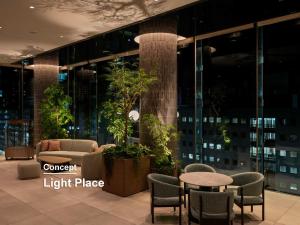 a lobby of a high rise building with tables and chairs at Mitsui Garden Hotel Sendai - Reopening on June 14 in Sendai