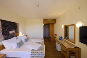 a hotel room with two beds and a desk at Shefayim Kibbutz Hotel in Kibbutz Shefayim +48 photos