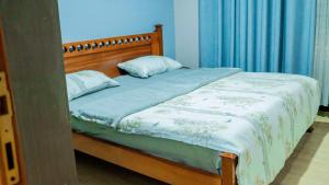 a bed with two pillows on it in a bedroom at Kigali Airport Stay Apartments in Kigali