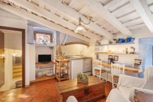 Una cocina y una sala de estar con mesa y sillas. en Casa del Pastor-Brugarolas Village, en Castelltersol
