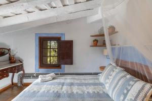 un dormitorio con una cama y una ventana en Casa del Pastor-Brugarolas Village, en Castelltersol