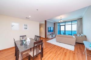 a living room with a table and a couch at Sunset Beach View Holiday Homes in Ajman 