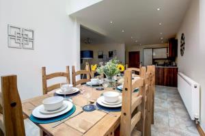 una mesa de comedor de madera con sillas y un tablero en Albert Stays - 5 bed Sleeps 11 - Free Parking, en Preston
