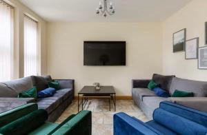ein Wohnzimmer mit zwei Sofas und einem Fernseher in der Unterkunft Albert Stays - 5 bed Sleeps 11 - Free Parking in Preston