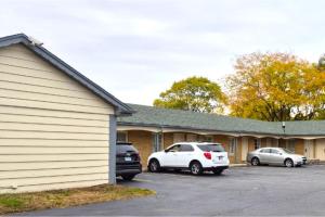 two cars parked in a parking lot next to a building at Capital O Elite Inn & Suites South Holland I 94 in South Holland