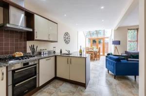 eine Küche mit Herd Top-Backofen neben einem Wohnzimmer in der Unterkunft Albert Stays - 5 bed Sleeps 11 - Free Parking in Preston