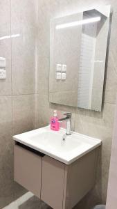 une salle de bains avec un lavabo blanc et un miroir dans l'établissement شقة راقية بغرفة نوم وصالة مريحة, à Hafr Al Baten