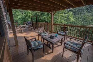 a porch with a table and chairs on a deck at Smoke Rise Barn · Great Lake Front, Large Dock, 4bdrm, Pool Table in Dandridge