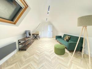 Blindley HeathにあるDippen Hall Signature Apartmentの緑のソファとテーブルのあるリビングルーム