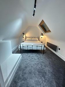 Blindley HeathにあるDippen Hall Signature Apartmentの白いベッドルーム(ベッド1台付)が備わります。