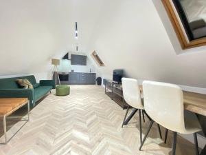 Blindley HeathにあるDippen Hall Signature Apartmentのソファとテーブルと椅子のあるリビングルーム