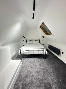 Blindley HeathにあるDippen Hall Signature Apartmentの白い部屋にあるベッドのある寝室