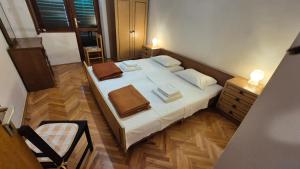 a small bedroom with a bed and a chair at Beachfront House with garden and two terraces in Tisno