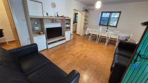 a living room with a couch and a kitchen with a table at Beachfront House with garden and two terraces in Tisno