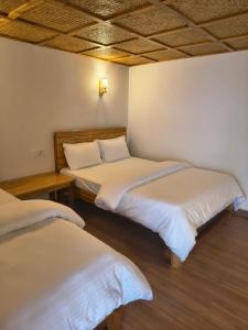a room with two beds in a room at RJ Boutique Hotel - Ghandruk in Astam
