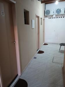a hallway with a row of doors and a tile floor at POUSADA AREIAS DE PAJUÇARA in Maceió