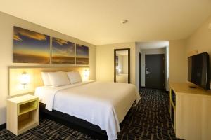 a hotel room with a bed and a flat screen tv at Days Inn by Wyndham Jackson in Jackson