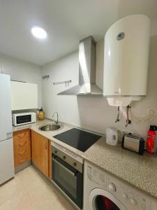 a kitchen with a sink and a stove top oven at Loma Blanca by Residea in Manilva +46 photos