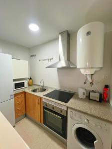 a kitchen with a sink and a washing machine at Loma Blanca by Residea in Manilva