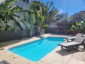 a small swimming pool with two chairs next to it at Villa Camille A8A in Grand-Baie