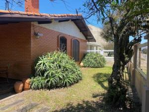 a house with some plants in the yard at Seu Lar em Imbè in Imbé