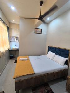 Un dormitorio con una cama con ventilador de techo. en Divine Fine Dine, en Kalyan