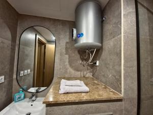 een badkamer met een wastafel en een spiegel bij Modern ZED Apartment Near Pyramids, ZED Park, GEM in Sheikh Zayed +44 foto's