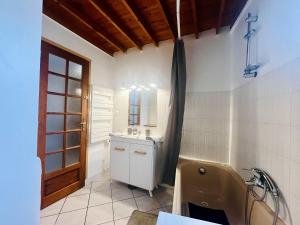a bathroom with a toilet and a sink and a tub at La Grange in Carentan
