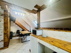 a kitchen with a counter and a table with a microwave at La Grange in Carentan