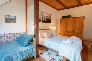 a bedroom with two beds and a bench in it at Apartman Osoj Mrzla Vodica in Mrzla Vodica