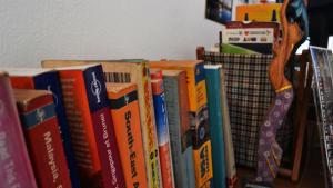 a pile of books sitting on top of a shelf at Ringo's Foyer in Melaka