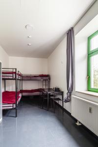 een kamer met een stapelbed, een tafel en een raam bij Kapselhotel nähe Hauptbahnhof Halle-Saale in Halle an der Saale