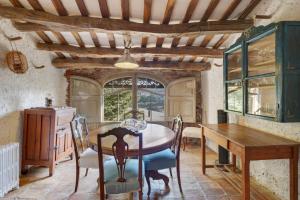 Un comedor con mesa y sillas y una ventana. en Brugarolas Village, en Castelltersol