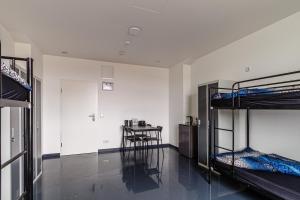 een kamer met 2 stapelbedden en een tafel bij Kapselhotel nähe Hauptbahnhof Halle-Saale in Halle an der Saale
