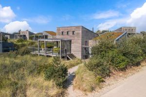a house on the side of a hill with a road at Super VIP Waterfront Villa - 4p - Waterzicht & Windbeschut Terras - Villa 42 in Ouddorp